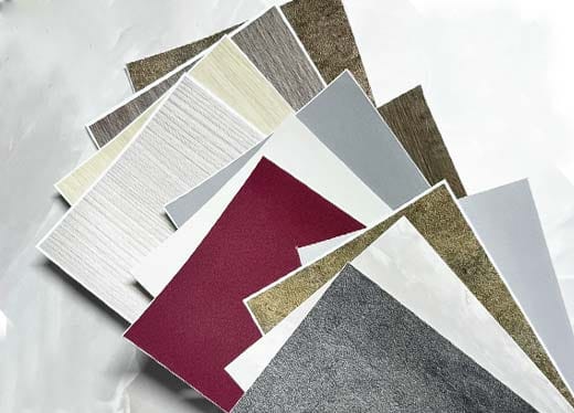 Korean interior film samples in wood, marble, solid colors, and textured finishes used for doors, cabinets, walls, and furniture in Dubai.